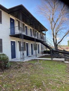 Jonesboro apartment for rent - a building with a staircase and a tree in front of it