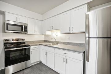 Hazel Park apartment for rent - A kitchen with white cabinets and stainless steel appliances.