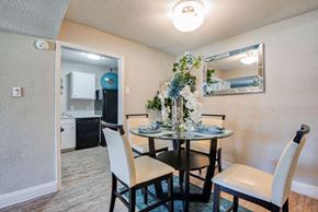 Houston apartment for rent - A dining room with a table set for two and a mirror above it.