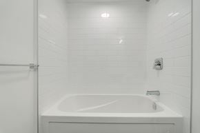 York apartment for rent - A white bathroom with a white tub and a white shower curtain.