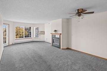 St. Cloud apartment for rent - A living room with a grey carpet and a ceiling fan.