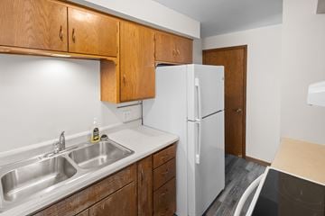 Buffalo apartment for rent - A kitchen with a white fridge and wooden cabinets.