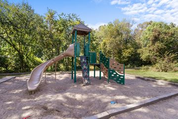 Plymouth apartment for rent - A playground with a slide and a wooden structure.
