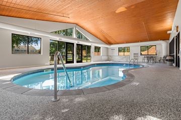 Bloomington apartment for rent - A round swimming pool in a room with a wooden ceiling.