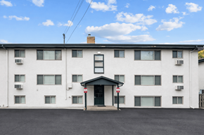 Richfield apartment for rent - A white building with a black roof and a red sign on the door.