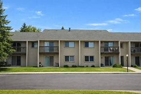 New Ulm apartment for rent - A large apartment building with a parking lot in front.