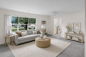 St. Louis Park apartment for rent - A living room with a grey couch, a round wicker table, and a grey rug.