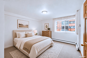 St. Louis Park apartment for rent - A bedroom with a large bed and a window with blinds.