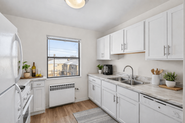 St. Louis Park apartment for rent - A kitchen with white cabinets and a window overlooking buildings.