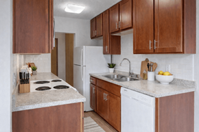 St. Louis Park apartment for rent - A kitchen with brown cabinets and a white fridge.