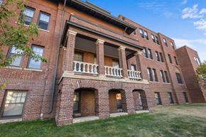 Minneapolis apartment for rent - A red brick building with a balcony in the middle.