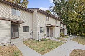 Prior Lake apartment for rent - A beige two-story apartment building with a brown roof and a small front yard.