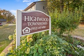 Prior Lake apartment for rent - A sign for Highwood Townhomes stands in front of a building and some trees.