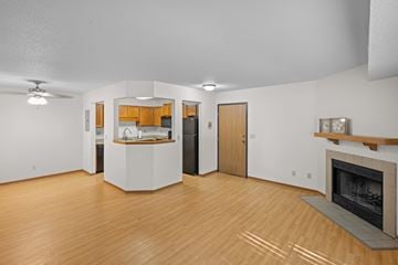 Chaska apartment for rent - A living room with a fireplace and a kitchen area in the background.