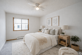 St. Louis Park apartment for rent - A bedroom with a large bed, a window, and a ceiling fan.