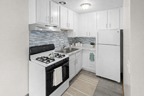 St. Louis Park apartment for rent - A kitchen with white cabinets and a black stove top oven.