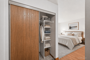 St. Louis Park apartment for rent - A bedroom with a large bed and a wooden wardrobe.