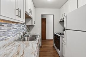 St. Louis Park apartment for rent - A kitchen with white cabinets and a marble countertop.