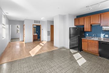 Minneapolis apartment for rent - A kitchen area with a black refrigerator and wooden cabinets.