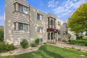 St. Louis Park apartment for rent - the front of a brick apartment building with green grass and trees
