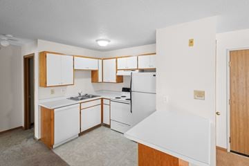 Buffalo apartment for rent - A kitchen with white appliances and wooden cabinets.