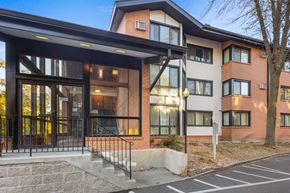 St. Louis Park apartment for rent - the facade of a new apartment building with glass doors and a staircase