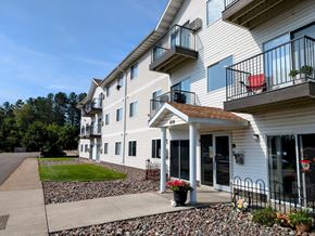 Cloquet apartment for rent - a view of the exterior of a building with a sidewalk and grass