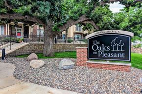 Richfield apartment for rent - the oaks on pleasant sign in front of trees and rocks