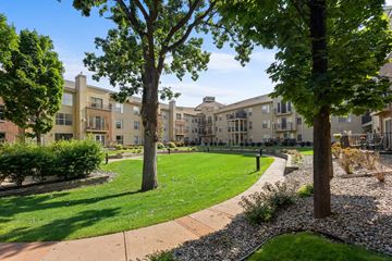 Richfield apartment for rent - A tree in a grassy area in front of apartment buildings.