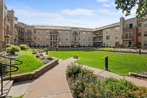 Richfield apartment for rent - A sunny day at a well-maintained apartment complex with a green lawn and walking paths.