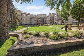 Richfield apartment for rent - a courtyard with trees and grass in front of an apartment building