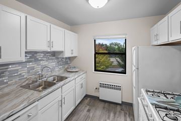 St. Louis Park apartment for rent - A kitchen with white cabinets and a window overlooking a street.