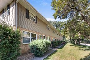 Buffalo apartment for rent - A building with a brown siding and a green lawn in front.