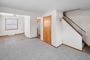 Buffalo apartment for rent - A room with a grey carpet and a wooden door.