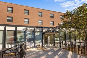 Minneapolis apartment for rent - a large brick building with a patio and a bench
