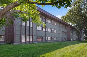 Brooklyn Park apartment for rent - A large building with a grassy area in front of it.