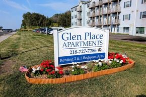 Duluth apartment for rent - a sign for glen place apartments in front of a garden of flowers