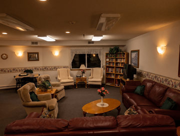 Onalaska apartment for rent - A living room with a brown leather couch and a round table with a vase of flowers on it.