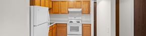 Wayzata apartment for rent - A white refrigerator is in a kitchen with wooden cabinets.