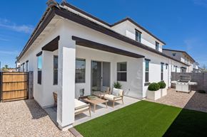 Mesa apartment for rent - A modern house with a white exterior and a patio area with a table and chairs.