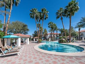Chandler apartment for rent - a large swimming pool with palm trees and lounge chairs