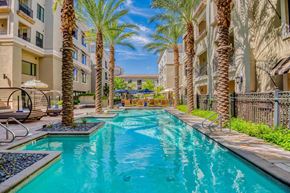 Scottsdale apartment for rent - a swimming pool with palm trees in front of a building