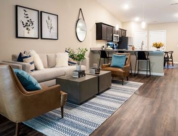 Cuyahoga Falls apartment for rent - a living room with a kitchen in the background and a blue and white rug