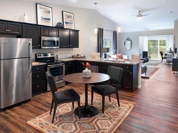 Fort Wayne apartment for rent - a kitchen with black cabinets and stainless steel appliances and a round table