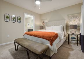 Mauldin apartment for rent - a bedroom with a bed and a bench in front of a closet