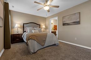 Altoona apartment for rent - A bedroom with a bed, two lamps, and a ceiling fan.