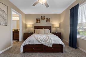 Ankeny apartment for rent - A bedroom with a large bed and a ceiling fan.