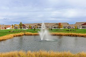Aurora apartment for rent - A fountain in the middle of a pond in front of a row of houses.