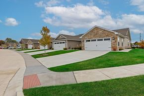 Aurora apartment for rent - A house with a driveway and a tree in front of it.
