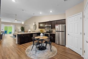Battle Creek apartment for rent - A modern kitchen with a dining table and chairs in the middle.
